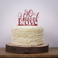 a cake with the words 40 years of love on it sitting on top of a wooden table