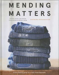 a stack of folded jeans sitting on top of a wooden table