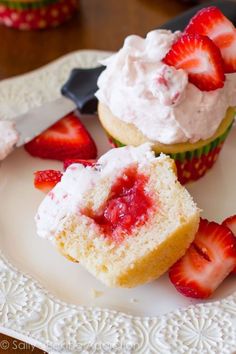 strawberry cupcakes with whipped cream and fresh strawberries on the top are ready to be eaten