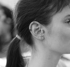 a woman with ear piercings in black and white