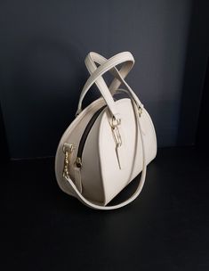 "For your consideration is this beautiful and oh so rare, vintage Coach Chadwick Bag, or Bowler (style #9928) in Bone or ivory-white, with brass hardware.  It is a \"Leatherware Era\" bag, and was made in the United Sates before 1994.  It is in Mint restored condition.  I consider this bag to be the Grail of vintage Coach purses, and is one of the most beautiful bags that Coach made during this era.  It is my favorite, and especially rare in bone.  The Chadwick satchel is a unique Coach style th Luxury Cream Satchel With Gold-tone Hardware, Luxury Cream Satchel With Top Handle, Luxury Cream Top Handle Shoulder Bag, Luxury Cream Top Handle Satchel, Classic Beige Bags For Formal Occasions, Beige Handheld Satchel For Evening, Classic Beige Formal Bags, Retro White Bag With Detachable Strap, White Retro Bag With Detachable Strap