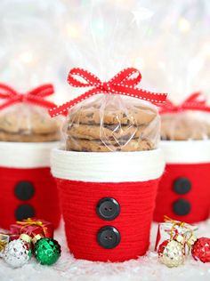 three red and white baskets filled with cookies in front of other christmas treats on a table