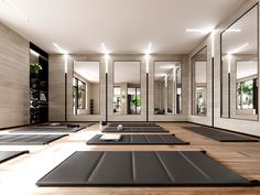 an empty yoga room with mirrors and mats on the floor in front of them,