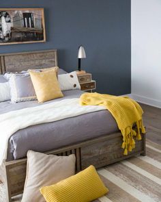 a bedroom with blue walls and yellow pillows