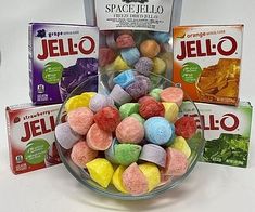 a bowl filled with jelly beans next to two packets of jello