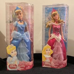 two disney princess dolls in plastic packaging on a table