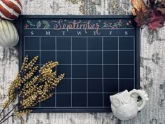 a chalkboard with writing on it next to autumn decorations