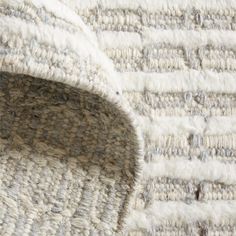 a close up view of a rug with white and grey stripes on the bottom half