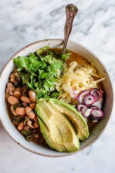 a bowl filled with beans, avocado and other vegetables