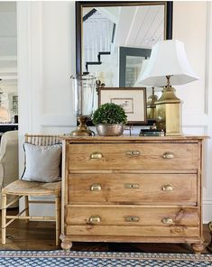 a wooden dresser sitting in front of a mirror