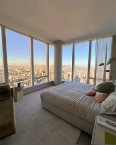 a bedroom with large windows overlooking the city