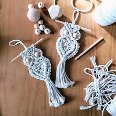 some yarns are laying on a table with balls of thread and wooden pegs