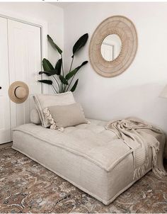 a living room with a chaise lounge in front of a mirror and potted plant