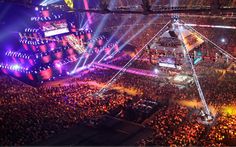 an aerial view of a concert venue at night with bright lights and people in the audience