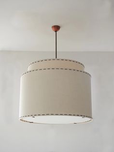 a light fixture hanging from the ceiling in a room with white walls and flooring