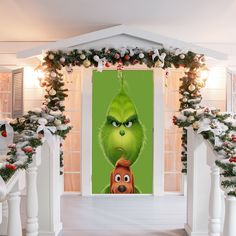 the grin movie poster is on display in front of christmas garlands and wreaths