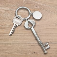 two keys are connected to each other on a wooden surface, one has a broken key