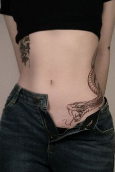 Serpent waist tattoo with a sleek and elongated design Sneak Tattoo Women, Snake Belly Tattoo, Snake Tattoo Waist, Snake Side Tattoo Women, Thigh Hip Tattoos Women, Lower Belly Tattoo, Abdomen Tattoo, Side Hip Tattoos, Purple Butterfly Tattoo