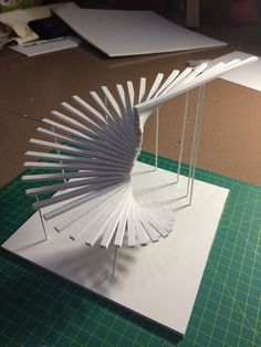 a sculpture made out of white paper sitting on top of a table