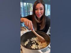 a woman stirring food in a pot on the stove