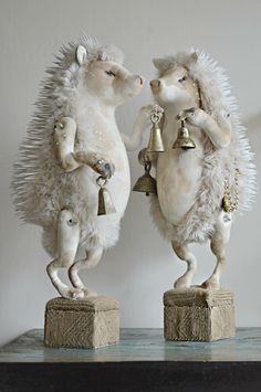 two statues of mice with bells on their heads and tails, one holding a bell