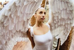 a woman is posing with an angel wings