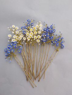 blue and white flowers are arranged on gold bobby pins