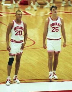 two basketball players standing in the middle of a court with their hands on their hips