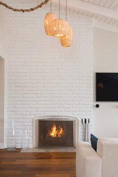 a living room with a white brick fireplace and tv mounted on the wall above it