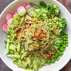 a white bowl filled with vegetables on top of a wooden table