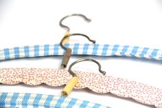 two blue and white checkered fabric hangers with metal hooks attached to the ends