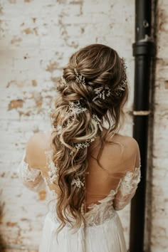 the back of a woman's head with long hair and flowers in her hair