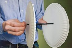 a man is holding a paper plate with a knife in it and cutting the bottom