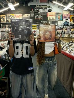 two people holding up records in front of their faces