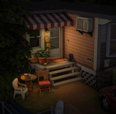 a small house with steps leading up to the front door and patio area at night