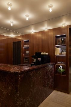 a marble counter top in a room with wooden walls and lighting on the ceiling above it