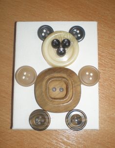 a bear made out of buttons sitting on top of a wooden table