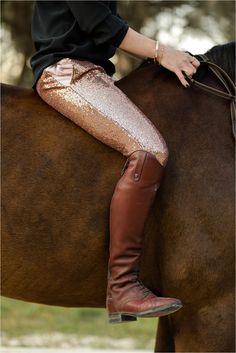 a woman riding on the back of a brown horse wearing sequin leggings