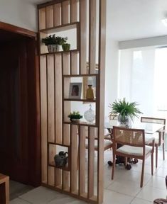 a living room filled with furniture next to a dining room table and two planters