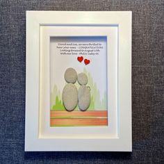 two rocks sitting on top of each other in a white frame with a poem written above them