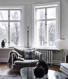 a living room filled with furniture and large windows