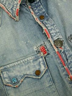 an old jean jacket with buttons and holes on it