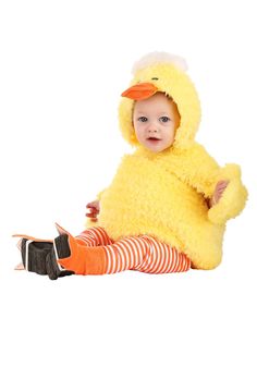 a baby in a yellow duck costume sitting on the floor with her legs crossed and feet crossed