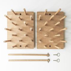 two wooden pegs are placed next to each other on a white surface with pins in them