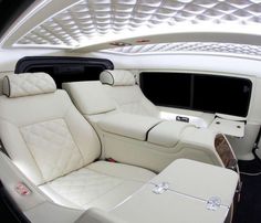 the interior of a luxury car with white leather seats