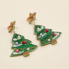 Spread holiday cheer with our Christmas Tree Beaded Earrings! Featuring a festive design of a Christmas tree made out of colorful beads, these earrings are the perfect accessory for the holiday season. Complete with star stud posts, they're sure to make you the star of any holiday party! Christmas Tree Beads, Tree Seeds, Festive Design, Holiday Outfit, Beaded Dangle Earrings, Dangling Earrings, Star Studs, Seed Bead Earrings, Bead Earrings