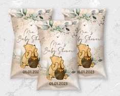 three winnie the pooh baby shower pillows on a white background with leaves and flowers