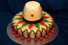 a cake decorated with raspberries and a white hat on it's top