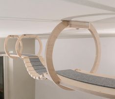 a cat bed hanging from the ceiling in a room with white walls and carpeted flooring