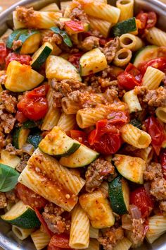 a bowl filled with pasta and vegetables on top of a table